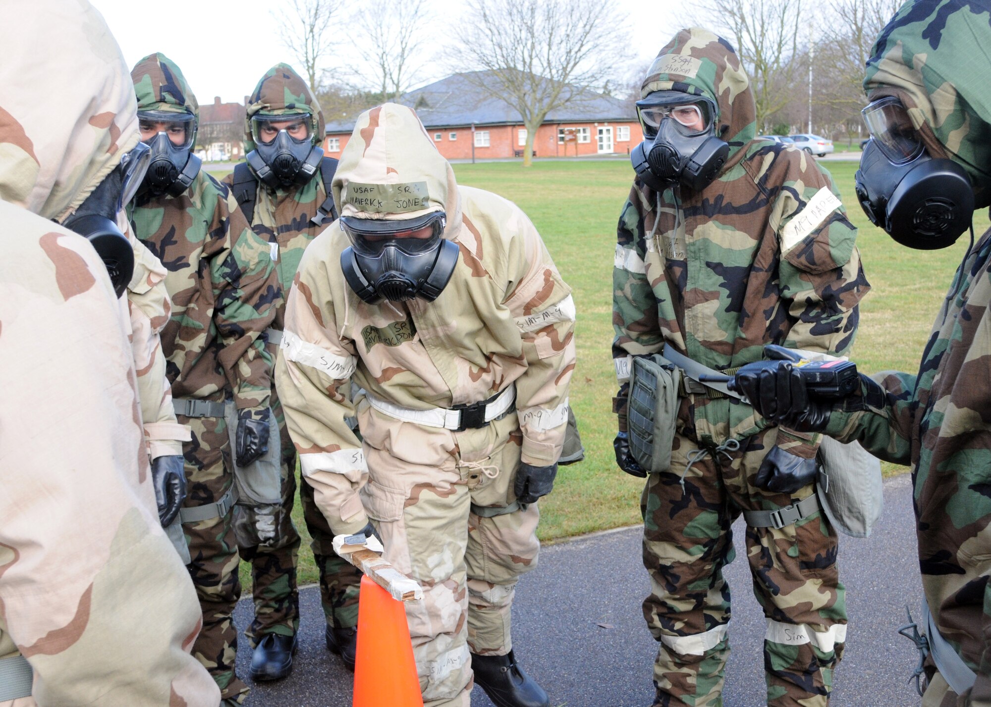Airmen inspect simulated M-9 paper during their chemical, biological, radiological and nuclear training Feb. 7, 2013, in outside building 680 at RAF Mildenhall, England. The M-9 paper is used as a way to detect and identify chemical weapons in a CBRN situation. (U.S. Air Force photo by Airman 1st Class Kelsey Waters/Released)