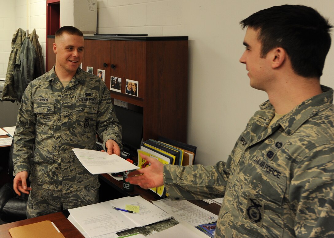 Airman 1st Class Robert Barnes, 28th Security Forces Squadron base defense operations controller, gives an allocation notice for an inbound Airman to Senior Airman Joshua Steinberg, 28th Security Forces Squadron supplies NCO in charge, at Ellsworth Air Force Base, S.D., Feb. 22, 2013. Barnes requested early separation from his four-year contract with the Air Force in order to pursue his dream of earning a commission with the Army. (U.S. Air Force photo by Airman 1st Class Hrair H. Palyan/Released)