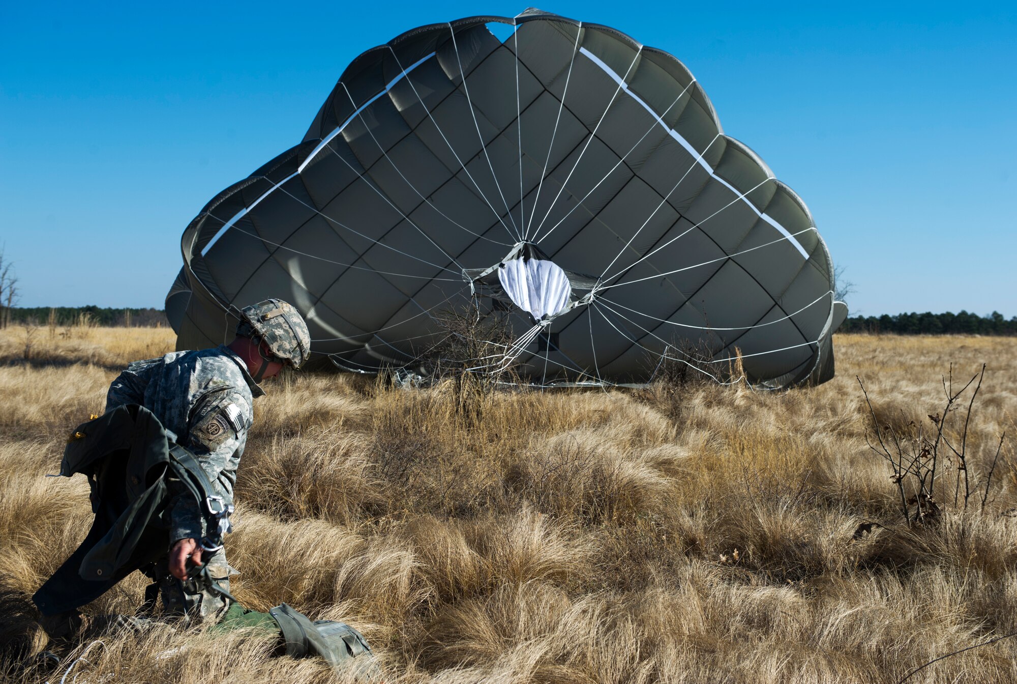 U.S. Army Staff Sgt. Andrew Williamson, a squad leader with Charlie Company, 1st Brigade, 82nd Airborne Division, lands after a static line airdrop during Joint Operational Access Exercise (JOAX) 13-02 at Camp Mackall, N.C., Feb. 24, 2013. A JOAX is designed to enhance service cohesiveness between Army and Air Force personnel, allowing both services an opportunity to properly execute large-scale heavy equipment and troop movement. (U.S. Air Force photo by Airman 1st Class Kyle Russell/Released)
