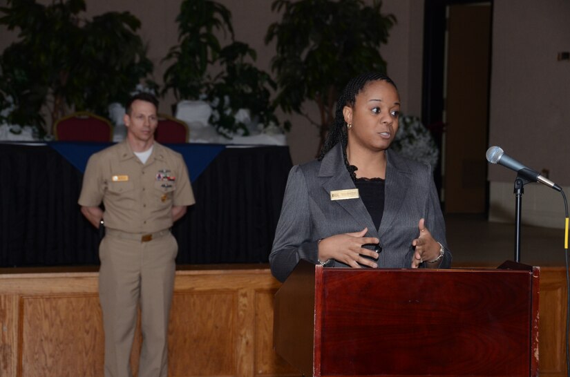 Tanya Bradfield, Fleet and Family Support Center representative, addresses the audience at the inaugural Joint Base Charleston Individual Augmentee Appreciation Luncheon Feb. 15, 2013, at the Redbank Club at JB Charleston – Weapons Station, S.C.  as Naval Support Activity Charleston Command Master Chief Billy Cady listens . Bradfield shared her perspective on Individual Augmentees and the impact the deployments have on families. Individual Augmentees perform duties outside of standard Navy platforms alongside Soldiers, Marines and Airmen world-wide. (U.S. Navy photo/Petty Officer 1st Class Chad Hallford)