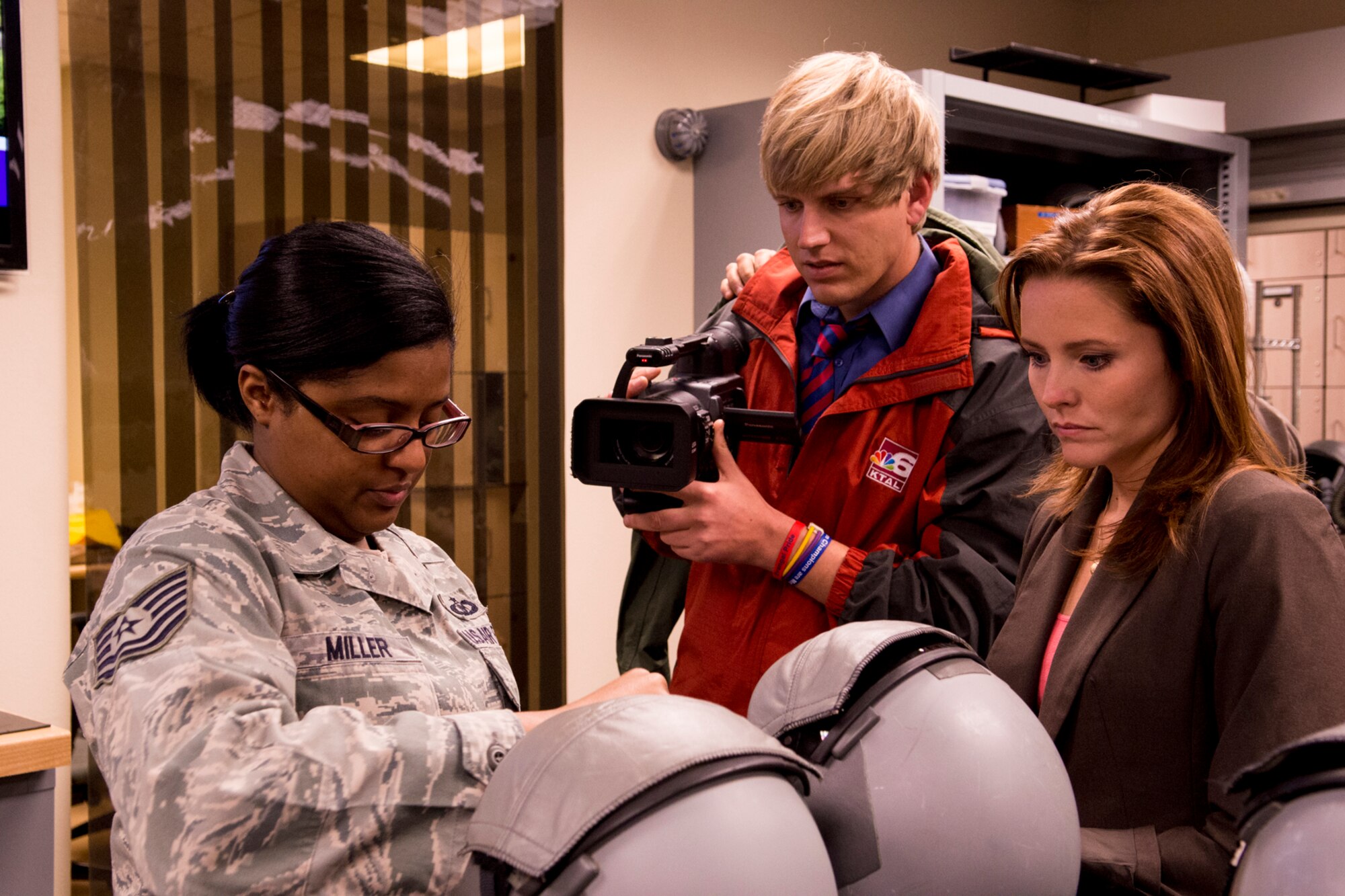 Joel Rodgers and Leslie Draffin, KTAL Channel 6 News reporters, watch U.S. Air Force Tech. Sgt. Melace Miller as she inspects two aircrew helmets they'll wear during a flight on a B-52H Stratofortress, Feb. 25, 2013, Barksdale Air Force Base, La. Rodgers and Draffin are reporting on the mission of the 93rd Bomb Squadron, which is assigned to the 307th Bomb Wing at Barksdale. (U.S. Air Force photo by Master Sgt. Greg Steele/Released)