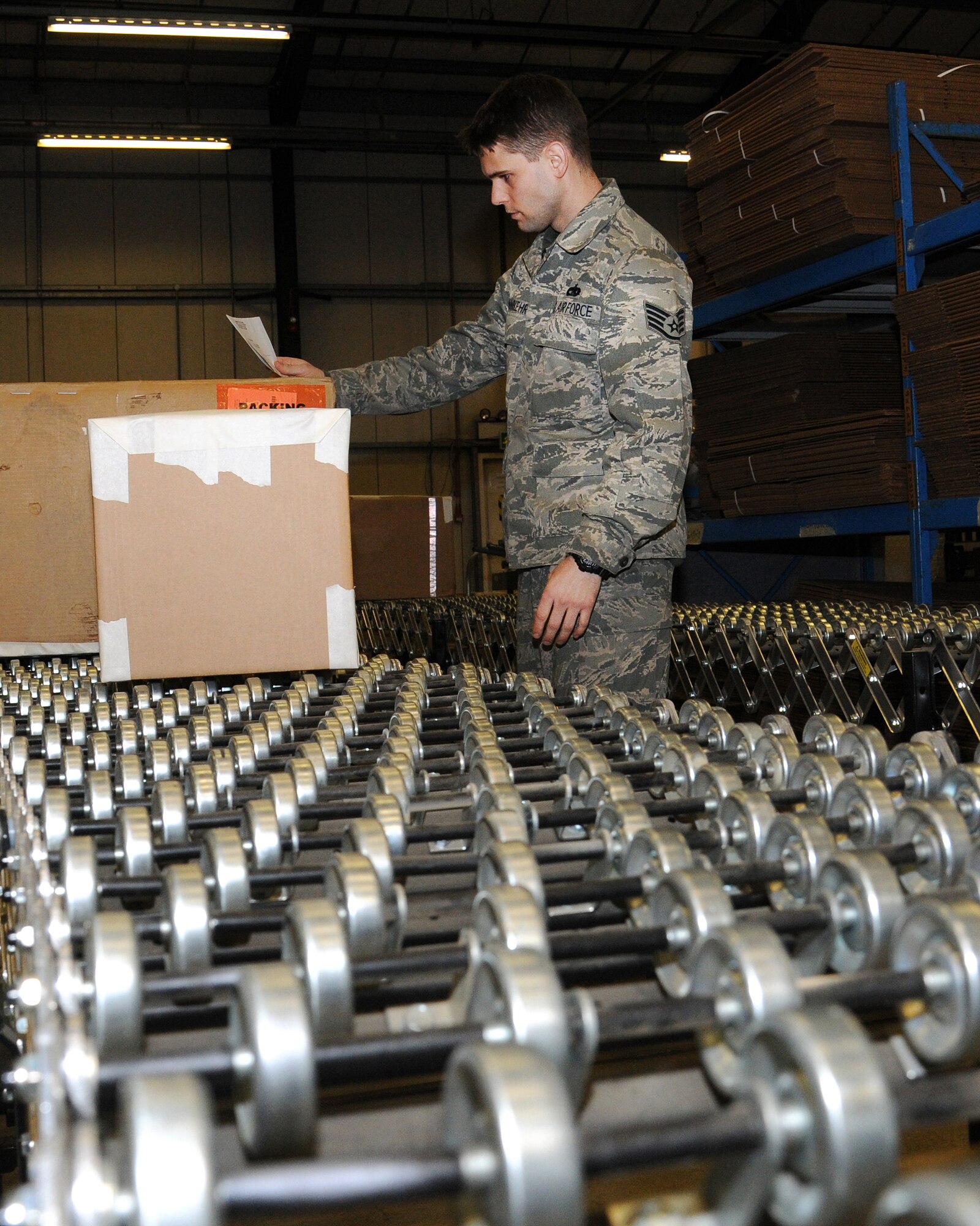 Staff Sgt. Filipi Wiederkehr, 100th Logistics Readiness Squadron traffic management craftsman from Sao Paulo, Brazil, inspects shipping labels and packaging worthiness prior to commercial carrier pick-up on Feb. 22, 2013, at RAF Mildenhall, England. The 100th LRS Cargo Movement Section processed more than 8,000 pieces of critical cargo in 2012. (U.S. Air Force photo by Gina Randall/Released)
