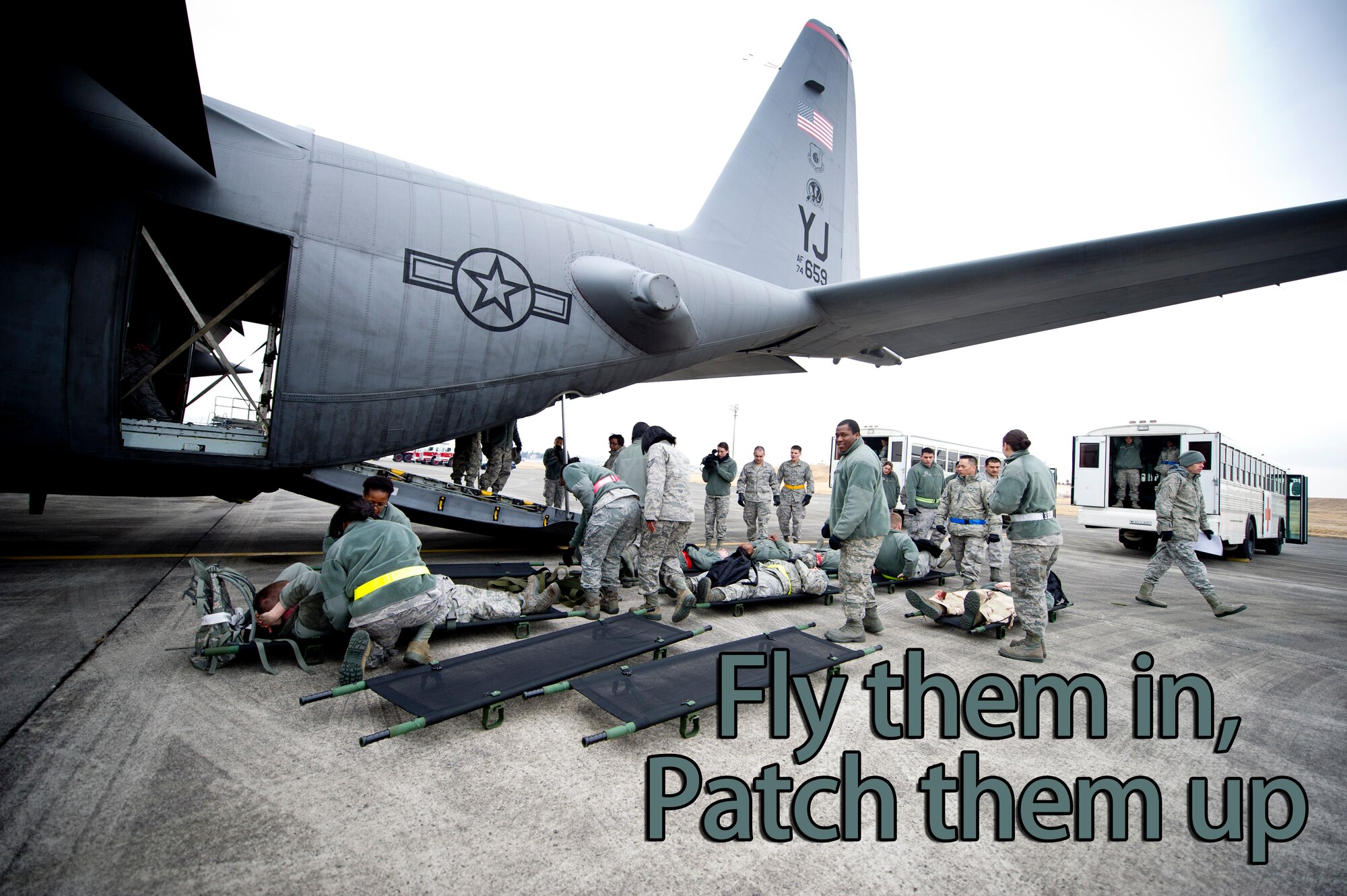YOKOTA AIR BASE, Japan -- Members from the 374th Medical Group load simulated patients onto litters and administer self-aid and buddy care during readiness week, at Yokota Air Base, Japan, Feb. 27, 2013. Once on the litters, the simulated patients were brought to a Contingency Aeromedical Staging Facility setup to train members to respond to real-world situations. (U.S. Air Force illustration by Staff Sgt. Stacy Moless)