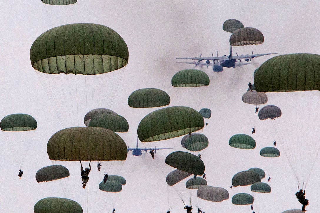 Paratroopers jump from C130 Hercules aircraft during a large airborne