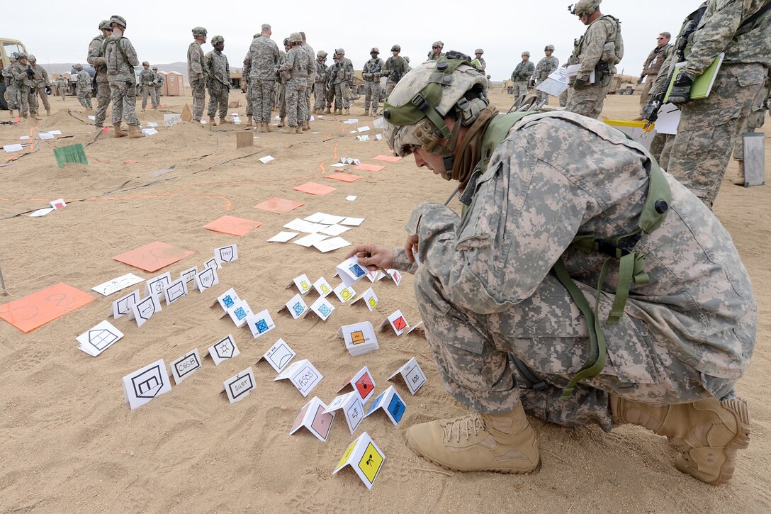Army Capt. Genaro Prieto arranges placards for a sand table in the Mojave Desert at the National Training Center on Fort Irwin, Calif., Feb. 21, 2013. Prieto, a engineer, is assigned to the 1st Infantry Division's 2nd Armored Brigade Combat Team.