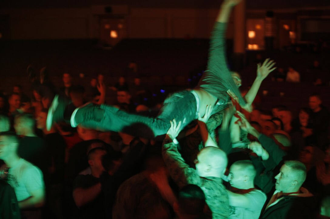 Marines and Sailors stage dive to the music of Queen Caveat during the Leathernecks II comedy and entertainment show.