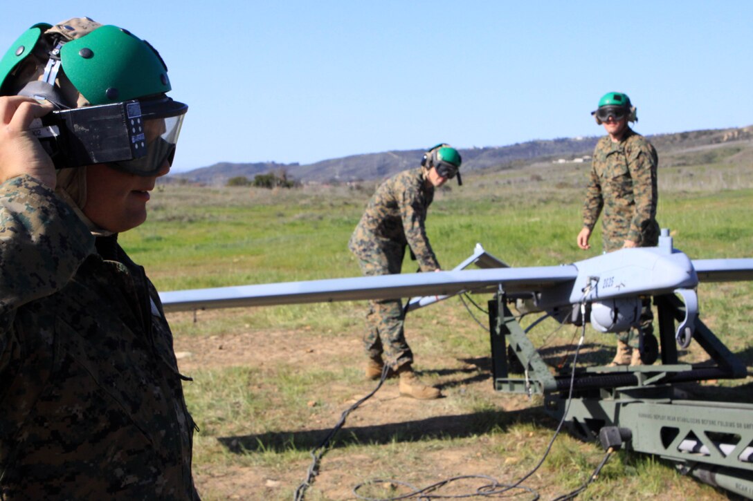 Sgt. Derrick Williams, left, communicates with the command center about wind calls as Sgt. Michael Lomartire, center, and Cpl. Andrew Smith, right, prepare the RQ-7B Shadow, an unmanned aerial vehicle, for a launch conducted here Feb. 27.
Williams was the plane captain and quality assurance chief for this exercise, and all of the Marines are UAV technicians from Marine Unmanned Vehicle Squadron 3 and VMU-4.
