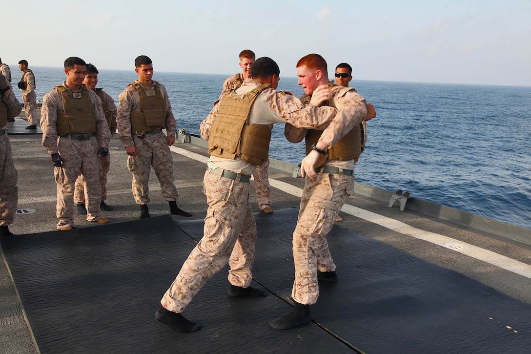 Lance Cpl. Jeffrey Cook(right), fire direction controller, 2nd Platoon, Battery B, Battalion Landing Team 3/5, 15th Marine Expeditionary Unit, practices moves from the Marine Corps Martial Arts Program with Lance Cpl. Marco Rodriguez, a field artillery cannoneer from the same platoon, aboard the USS Rushmore, Feb. 18. The 15th MEU is deployed as part of the Peleliu Amphibious Ready Group as a U.S. Central Command theater reserve force, providing support for maritime security operations and theater security cooperation efforts in the U.S. 5th Fleet area of responsibility. (U.S. Marine Corps photo by Cpl. Timothy R. Childers/ Released)