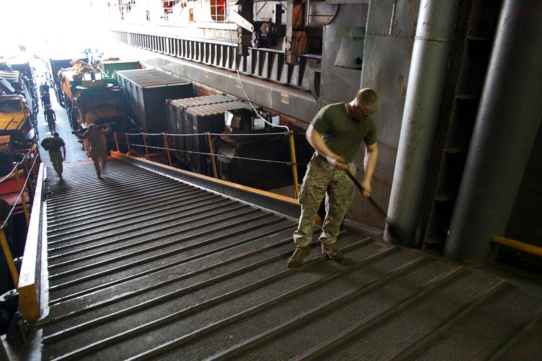 Lance Cpl. Jordan B. Thompson, combat cargoman, Ship's Company, USS Rushmore, sweeps the ramp leading into the well-deck of the USS Rushmore, Feb. 19. The 15th MEU is deployed as part of the Peleliu Amphibious Ready Group as a U.S. Central Command theater reserve force, providing support for maritime security operations and theater security cooperation efforts in the U.S. 5th Fleet area of responsibility. (U.S. Marine Corps photo by Cpl. Timothy R. Childers/Released)