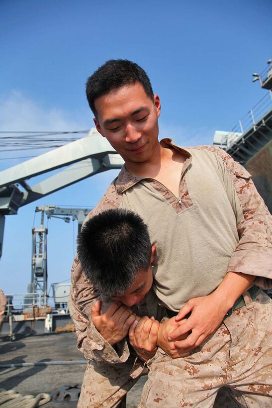 Corporal Byong Min, cannoneer, Battery B, Battalion Landing Team 3/5, 15th Marine Expeditionary Unit,  practices moves from the Marine Corps Martial Arts Program with Cpl. Bernard Vu, a field radio operator with the battery, aboard the USS Rushmore, Feb. 21. The 15th MEU is deployed as part of the Peleliu Amphibious Ready Group as a U.S. Central Command theater reserve force, providing support for maritime security operations and theater security cooperation efforts in the U.S. 5th Fleet area of responsibility. (U.S. Marine Corps photo by Cpl. Timothy R. Childers/ Released)