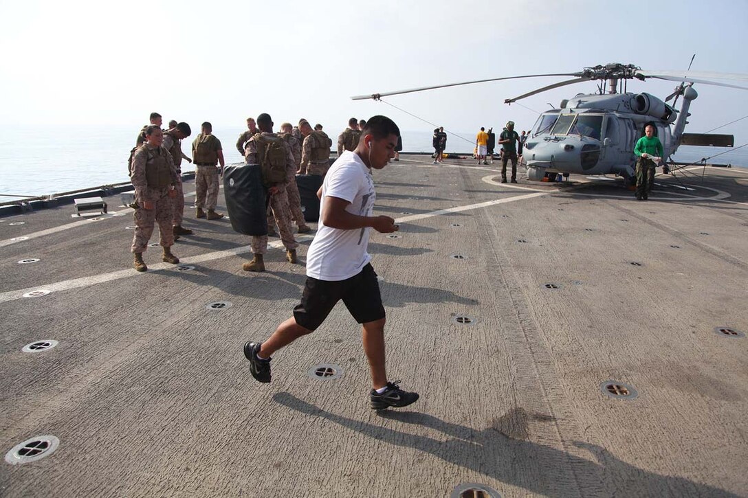 Corporal Omar Vegamendoza, motor transportation operator, Battery B, Battalion Landing Team 3/5, 15th Marine Expeditionary Unit,  runs on the flight deck of the USS Rushmore, Feb. 21. The 15th MEU is deployed as part of the Peleliu Amphibious Ready Group as a U.S. Central Command theater reserve force, providing support for maritime security operations and theater security cooperation efforts in the U.S. 5th Fleet area of responsibility. (U.S. Marine Corps photo by Cpl. Timothy R. Childers/ Released)