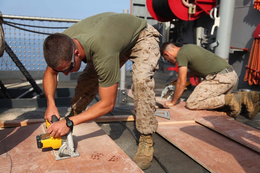 Lance Cpl. Charles F. Irish, combat engineer, Engineer Detachment, Combat Logistics Battalion 15, 15th Marine Expeditionary Unit, cuts a sheet of plywood to build a target aboard the USS Rushmore, Feb. 21. The 15th MEU is deployed as part of the Peleliu Amphibious Ready Group as a U.S. Central Command theater reserve force, providing support for maritime security operations and theater security cooperation efforts in the U.S. 5th Fleet area of responsibility. (U.S. Marine Corps photo by Cpl. Timothy R. Childers/ Released)