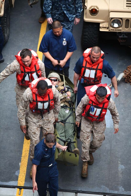 Sailors assigned to the 15th Marine Expeditionary Unit and USS Rushmore conduct casualty evacuation training aboard the USS Rushmore, Feb. 25. Servicemembers took advantage of their time at sea to conduct Maritime Interoperability Training that touched on a number of areas the Marines were unfamiliar with, including at-sea casualty evacuations, small boat proficiency and live-fire gunnery training. The 15th MEU is deployed as part of the Peleliu Amphibious Ready Group as a U.S. Central Command theater reserve force, providing support for maritime security operations and theater security cooperation efforts in the U.S. 5th Fleet area of responsibility. (U.S. Marine Corps photo by Cpl. Timothy R. Childers/Released)