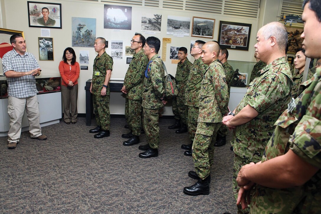Chris Majewski greets members of the Japan Ground Self-Defense Force Feb. 22 at the Battle of Okinawa historical display on Camp Kinser. The JGSDF members were given a guided tour of the display by Majewski, who took them through the history of both the Japanese and American sides of the battle. Majewski is the director of the Battle of Okinawa historical display. The JGSDF members are with the 15th Brigade, Western Army. 