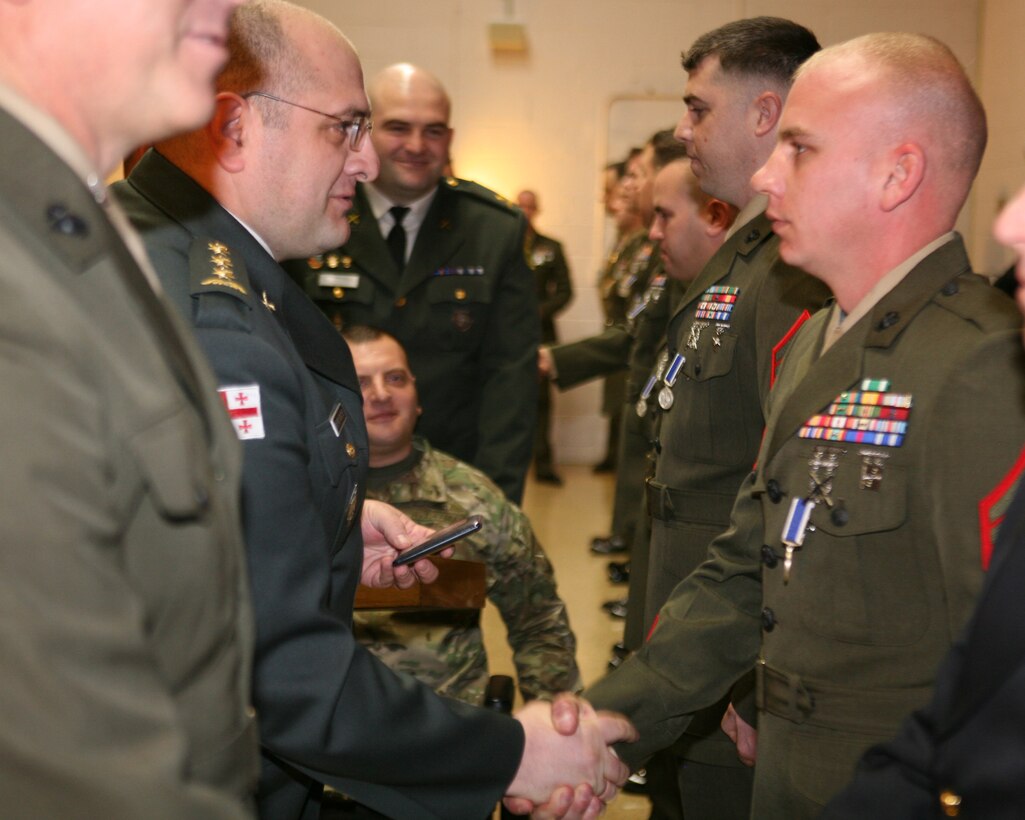 Republic of Georgia Col. Lasha Beridze, Deputy Chief of Defense, Georgian Armed Forces, awards Marine Staff Sgt. Joshua Sims, logistics chief, Georgia Liaison Team, with Republic of Georgia’s Peacekeeping Operations Medal, during an award ceremony aboard Joint Expeditionary Base Little Creek – Fort Story in Virginia Beach, Va., Feb. 28. The Republic of Georgia’s Peacekeeping Operations Medal is presented in recognition of a servicemember’s significant contributions to Georgian Armed Forces peacekeeping and combat operations.