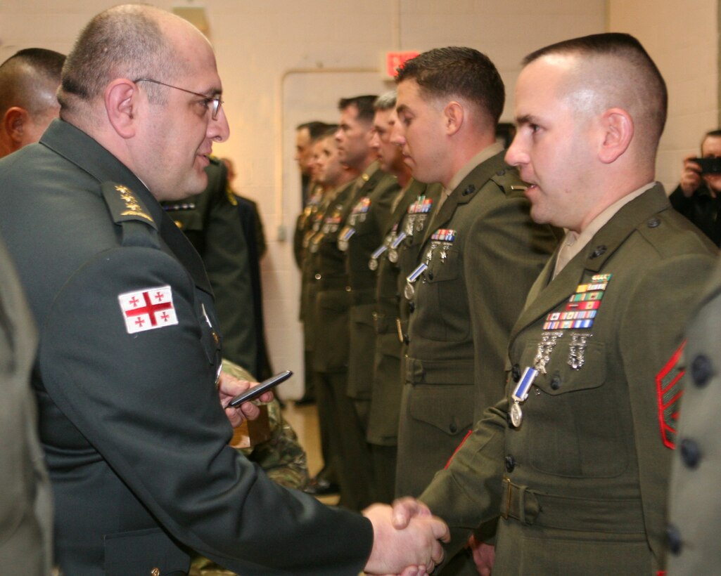 Republic of Georgia Col. Lasha Beridze, Deputy Chief of Defense, Georgian Armed Forces, awards Marine Gunnery Sgt. Adam Cortese, staff-noncommissioned officer-in-charge, Georgia Liaison Team, with Republic of Georgia’s Peacekeeping Operations Medal, during an award ceremony aboard Joint Expeditionary Base Little Creek – Fort Story in Virginia Beach, Va., Feb. 28. The Republic of Georgia’s Peacekeeping Operations Medal is presented in recognition of a servicemember’s significant contributions to Georgian Armed Forces peacekeeping and combat operations.