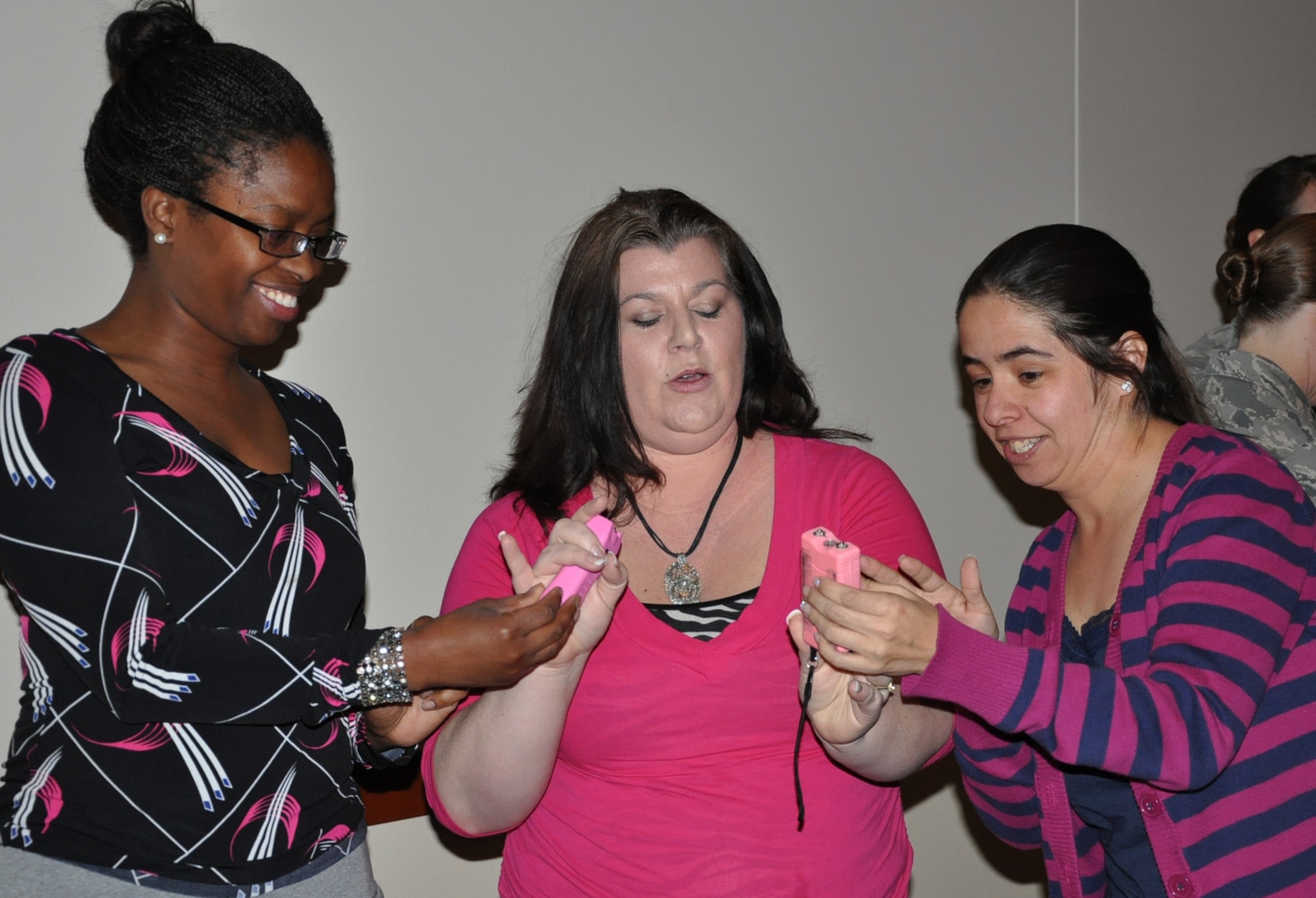 April Dobson, 460th Operations Group, left, and Erika Campbell, U.S. Army spouse, right, listen to Jenell Brooks, Team Buckley spouse, as she explains the appropriate and safe way to test a stun gun during the Ladies’ Empowerment Social and Book Club event Feb. 27, 2013, at the Leadership Development Center, Buckley Air Force Base, Colo. Approximately 40 women attended the social, which was part one of a two-part series about self defense.  (U.S. Air Force photo by Staff Sgt. Kali L. Gradishar/Released)