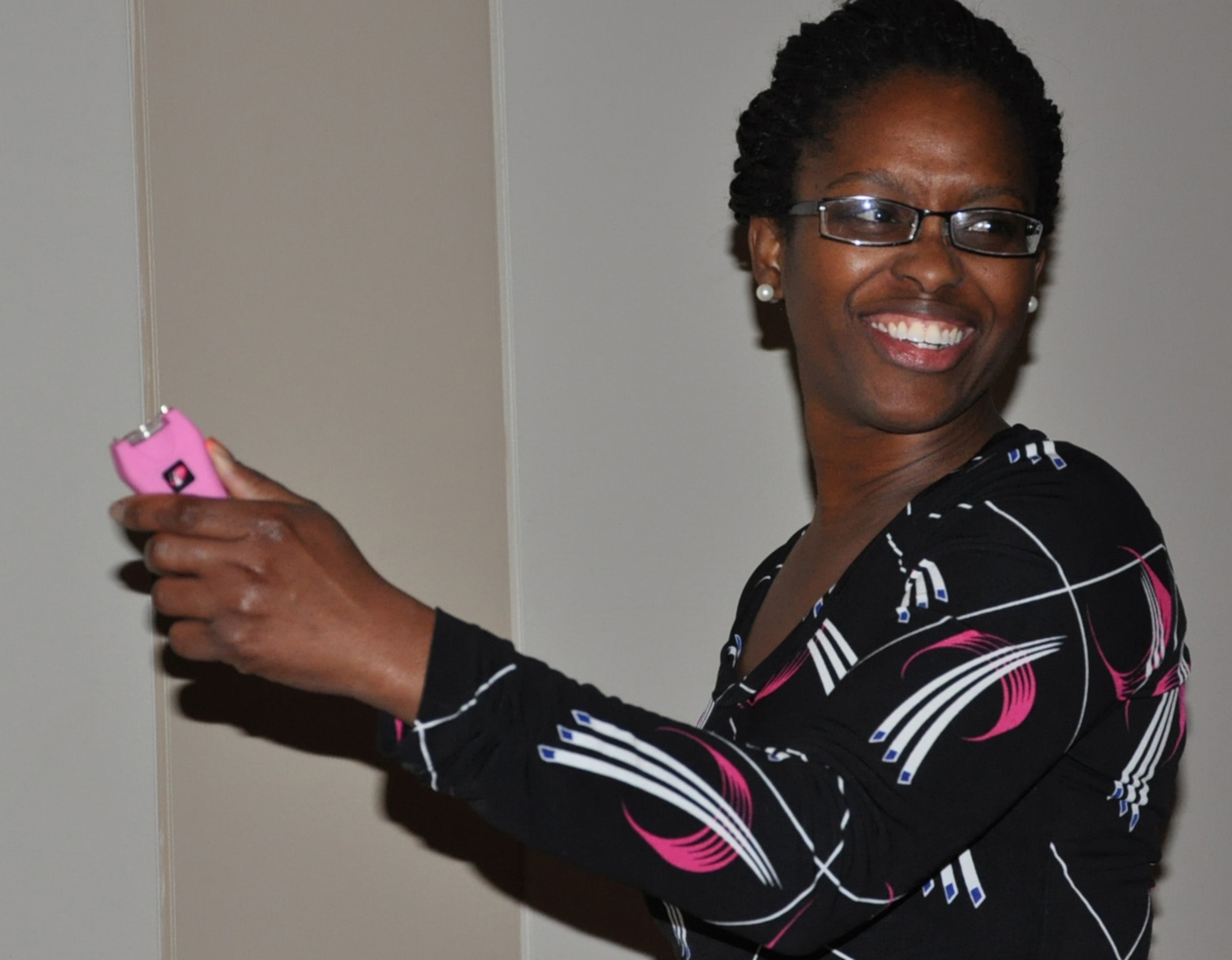 April Dobson, 460th Operations Group,  tests a stun gun during the Ladies’ Empowerment Social and Book Club event Feb. 27, 2013, at the Leadership Development Center, Buckley Air Force Base, Colo. Approximately 40 women attended the social, which was part one of a two-part series about self defense.  Attendees were able to view and handle self-defense products such as stun guns, pepper spray and various travel security items. Many women held and operated a stun gun for the first time. (U.S. Air Force photo by Staff Sgt. Kali L. Gradishar/Released)