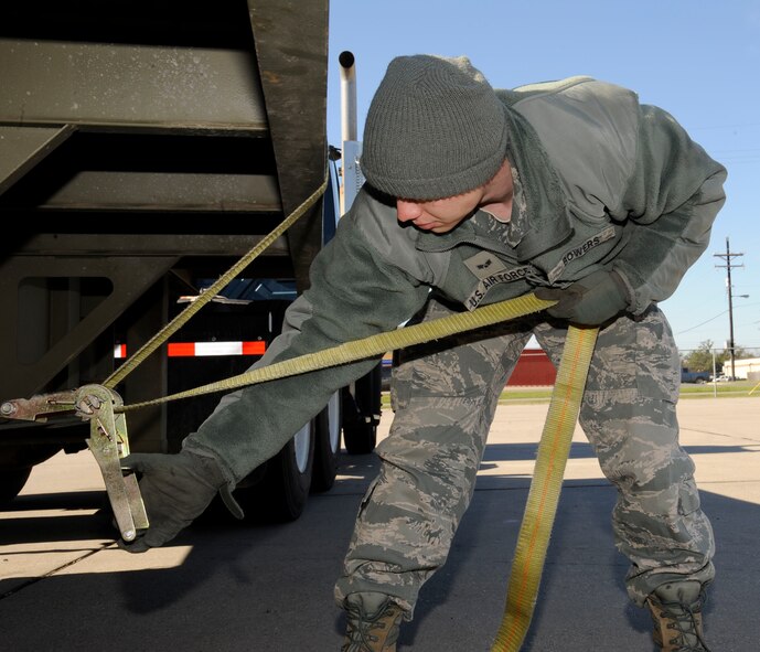 Senior Airman Jesse Bowers, 2nd Logistics Readiness Squadron Vehicle Operations, loosens a tow strap on a flatbed truck on Barksdale Air Force Base, La., Feb. 28. The Vehicle Ops section helps further Barksdale's mission of delivering precision munitions to the battlefield by providing transportation for aircrew and shipping and receiving parts for aircraft. (U.S. Air Force photo/Airman 1st Class Andrew Moua)