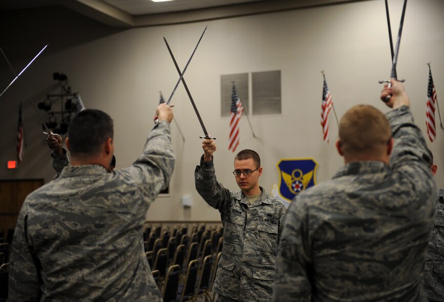 Airmen from the Barksdale Honor Guard Alpha Flight perform a saber cordon procedure on Barksdale Air Force Base, La., Feb. 28. Airmen walk under a saber cordon during promotion ceremonies to signify the transition of a junior Airman entering the NCO ranks and an NCO entering the senior NCO ranks. It is also used to recognize winners and nominees for awards. (U.S. Air Force photo/Airman 1st Class Benjamin Gonsier)
