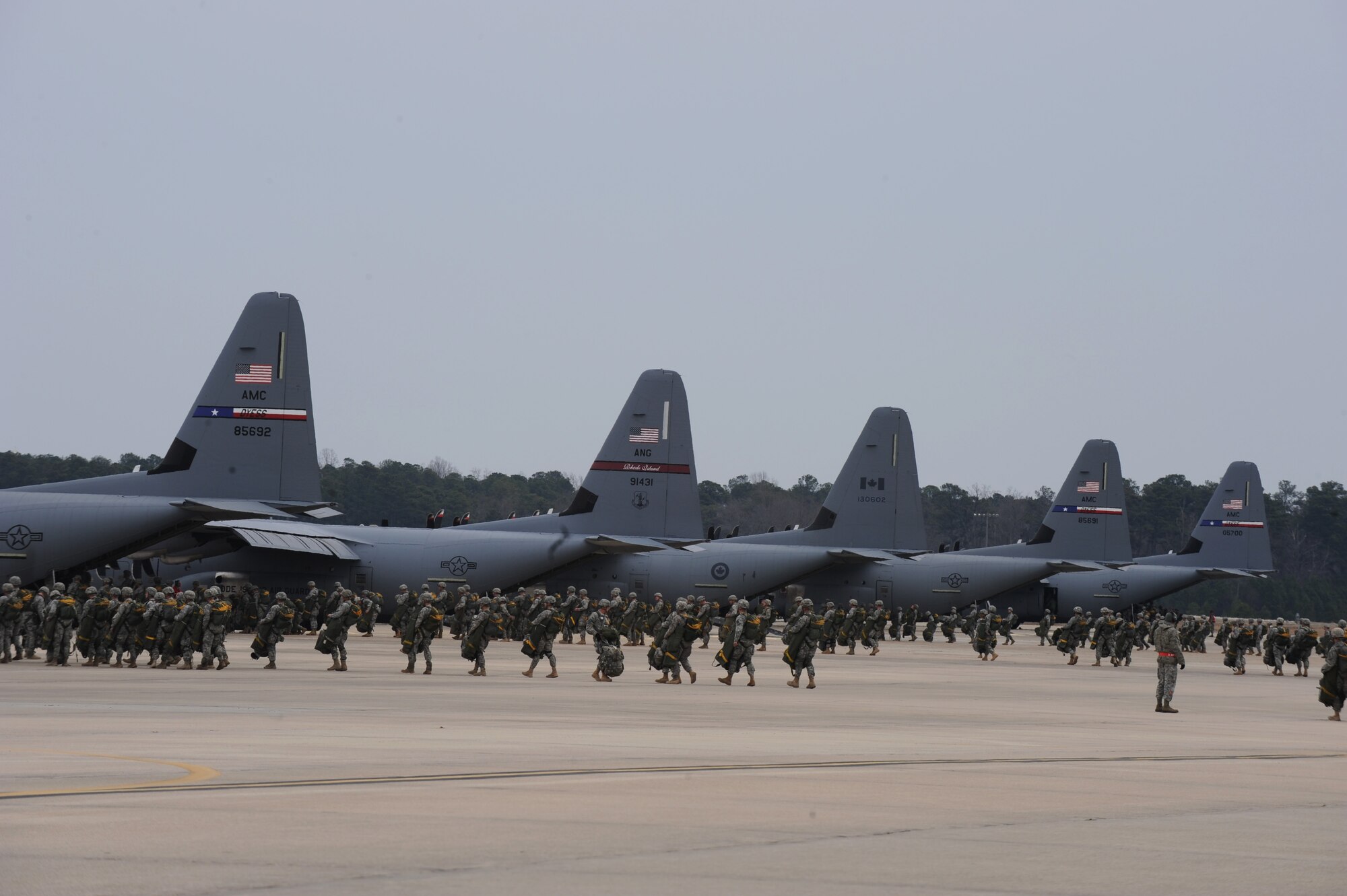 U.S. Army paratroopers board a U.S. Air Force C-130s and Royal Canadian Air Force CC-130s to complete a static line air drop, Feb. 25, 2015, Fort Bragg, N.C. The Joint Operational Access Exercise (JOAX) 13-02 is a combined exercise to prepare elements of the 82nd Airborne Division, along with its partners and enablers to respond as part of the Global Response Force (GRF). (U.S. Air Force photo by Senior Airman Jaclyn McDonald/Released)