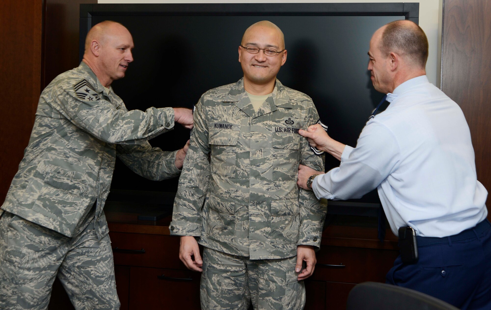 Chief Master Sgt. Scott A. Fuller, Air Force District of Washington command chief (left) and Col. Michael E. Gantt, AFDW vice commander “tack” on senior master sergeant stripes on selectee Master Sgt. Frank T. Kuwanoe, AFDW Intelligence superintendent, on Joint Base Andrew, Md., Feb. 28, 2013.  There were 12,834 eligible master sergeants and Kuwanoe was among the 1,367 selected for promotion to the rank of senior master sergeant.   (U.S. Air Force photo by Staff Sgt. Christopher Ruano)