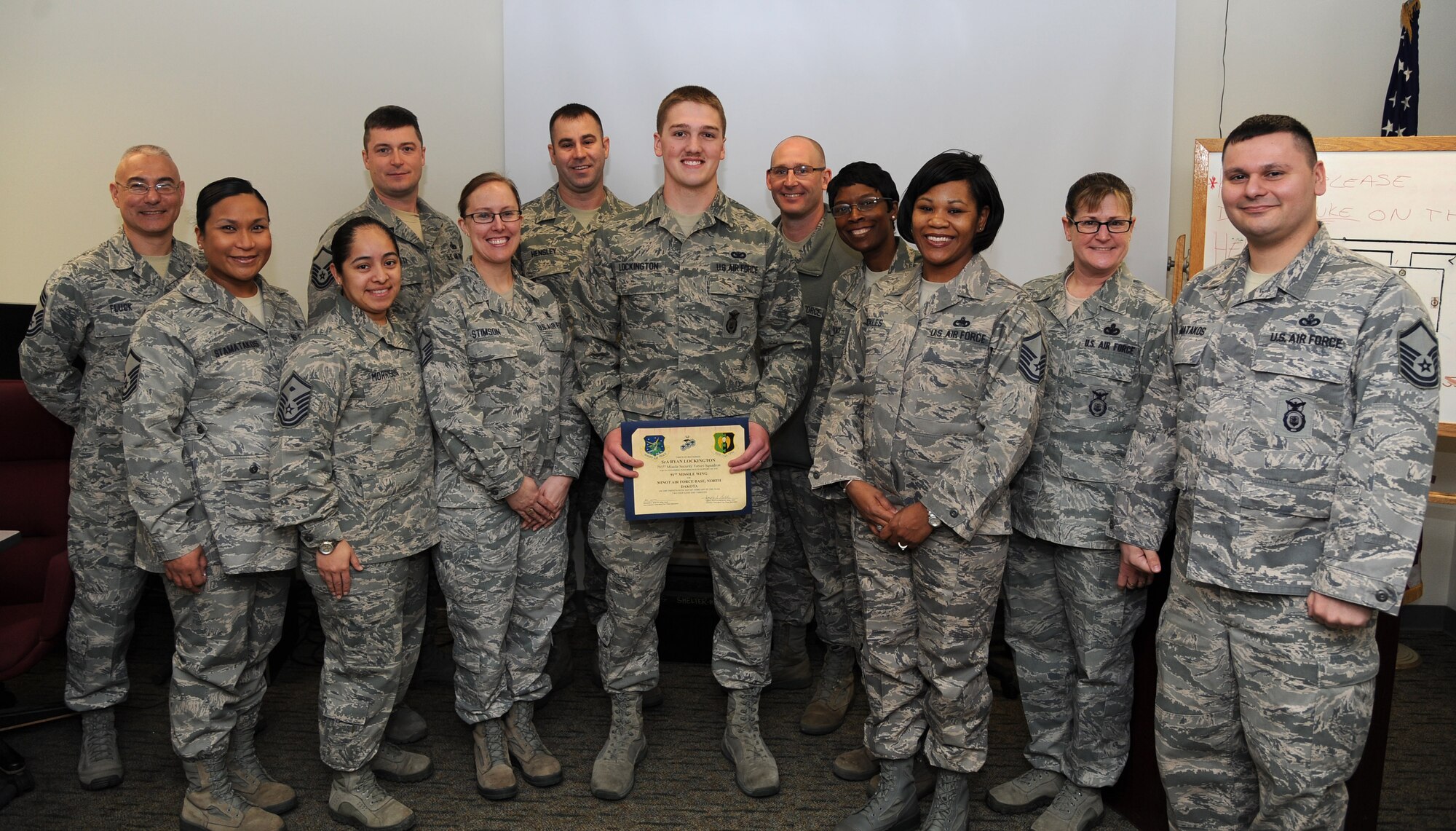 MINOT AIR FORCE BASE, N.D. -- Senior Airman Ryan Lockington, 791st Missile Security Forces Squadron response force leader, is presented the Top 3 Award by members of the organization here Feb. 25. Lockington received this award for his superior leadership and support to his fellow Airmen. Among his many accomplishments was leading 694 hours of security in support of maintenance operations, co-managing the flight fitness program and managing the end of tour of duty report program. (U.S. Air Force photo/Airman 1st Class Andrew Crawford)