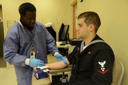 Department of Veterans Affairs Phlebotomist Eric Lundy prepares to draw blood from Navy Petty Officer 3rd Class Garrett Stoll at Naval Health Clinic Charleston at Joint Base Charleston – Weapons Station, Feb. 22, 2013. Lundy draws both Department of Veterans Affairs and Navy patients alike under the Lowcountry Federal Healthcare Alliance. (US Navy photo/ Petty Officer 1st Class Chad Hallford)