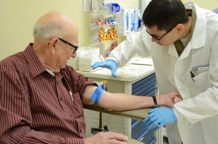 Navy Petty Officer 3rd Class John Betts prepares to draw blood from veteran John Newton at Naval Health Clinic Charleston at Joint Base Charleston – Weapons Station, Feb. 22, 2013. Betts provides health care for both Department of Navy and Veterans Affairs patients under the Lowcountry Federal Healthcare Alliance. (US Navy photo/ Petty Officer 1st Class Chad Hallford)