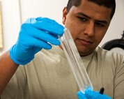 Staff Sgt. Carlos Cardoza, 47th Flying Training Wing Precision Measurement Equipment Laboratory physical dimensional supervisor, displays a container used to help calibrate devices that use thermometers called the triple point of water, because water exists in the form of a solid, liquid and gas inside it, at the PMEL shop on Laughlin Air Force Base, Texas, Feb. 26, 2013. PMEL technicians work to ensure that measurement equipment ranging from scales at the base gym to aircraft gauges provide accurate information.  (U.S. Air Force photo/Senior Airman Nathan Maysonet)