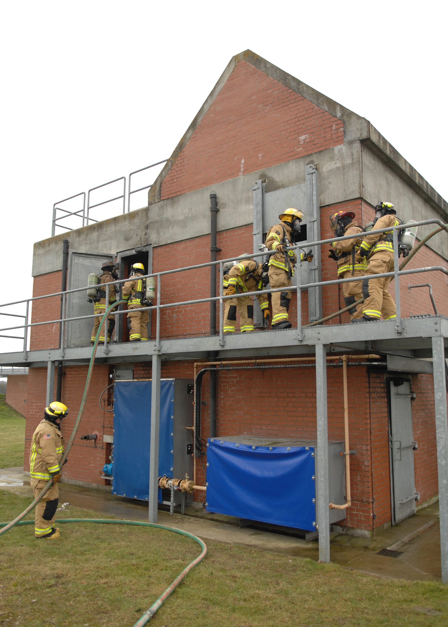 Firefighters from the 100th Civil Engineer Squadron Fire Department prepare an exercise scenario on the second floor of the structural trainer Feb. 20, 2013, at RAF Mildenhall, England. The firefighters train regularly on structural, aircraft and compartmental fires to ensure a quick and effective response in real-world situations. (U.S. Air Force photo by Airman 1st Class Dillon Johnston/Released)