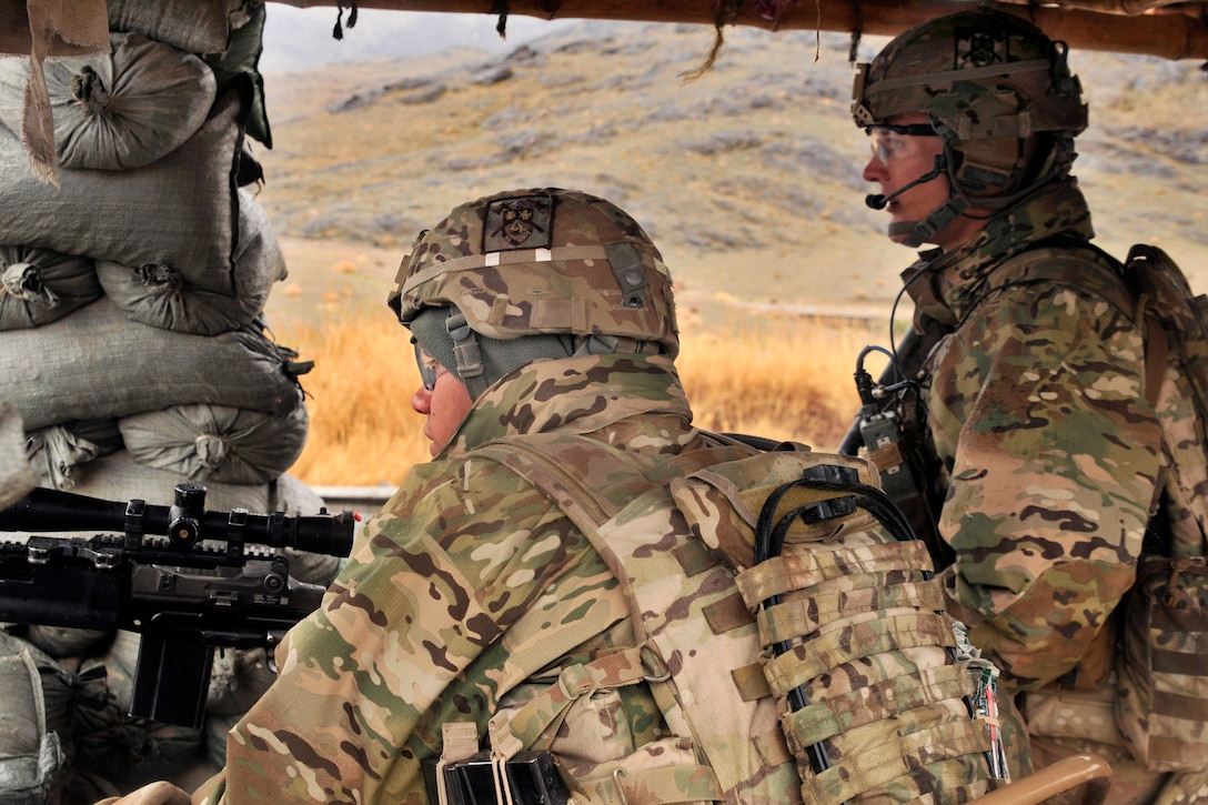 U.S. Army Spc. Alan L. Villalobos, left, and U.S. Army 1st Lt. James D. Whitler discuss security as Afghan Uniform Police officers prepare to establish a traffic checkpoint near Takhteh Pol in Kandahar province, Afghanistan, Feb. 26, 2013. Villalobos, an infantryman, and Whitler, a platoon leader, are assigned to the 2nd Infantry Division's Company B, 2nd Battalion, 23rd Infantry Regiment.