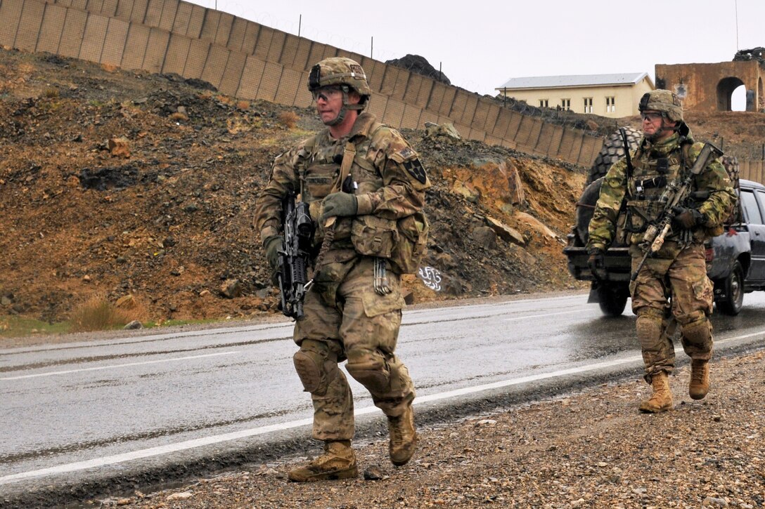 U.S. Army Spc. Bryan Gonzalez, left, and U.S. Army Sgt. Joshua D. Nix prepare to secure the area around an Afghan Uniform Police checkpoint near Takhteh Pol in Kandahar province, Afghanistan, Feb. 26, 2013. Gonzalez and Nix are infantrymen assigned to the 2nd Infantry Division's Company B, 2nd Battalion, 23rd Infantry Regiment.