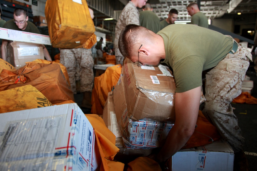Lance Cpl. Anthony C. Derby, rifleman, 1st Platoon, Kilo Company, Battalion Landing Team 3/5, 15th Marine Expeditionary Unit, sorts mail in the hangar bay of the USS Peleliu, Dec. 20. The ship received more than 10,000 pounds of mail during a replenishment at-sea. The 15th MEU is deployed as part of the Peleliu Amphibious Ready Group as a U.S. Central Command theater reserve force, providing support for maritime security operations and theater security cooperation efforts in the U.S. 5th Fleet area of responsibility. Derby, 20, is from Bloomfield, N.Y.  