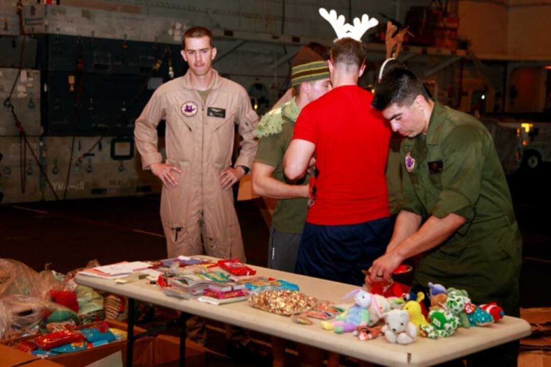 Staff Sgt. Enrique Aceves, maintenance controller, Marine Medium Helicopter Squadron 364 (Rein.), 15th Marine Expeditionary Unit, displays items donated to the unit for Christmas in the hangar bay of the USS Peleliu, Dec. 14. The gifts were donated to the unit by Operation Santa, a charity group coordinated through the unit’s family readiness officer to provide stockings to deployed servicemembers. The 15th MEU is deployed as part of the Peleliu Amphibious Ready Group as a U.S. Central Command theater reserve force, providing support for maritime security operations and theater security cooperation efforts in the U.S. 5th Fleet area of responsibility. Aceves, 34, is from Austin, Texas. 