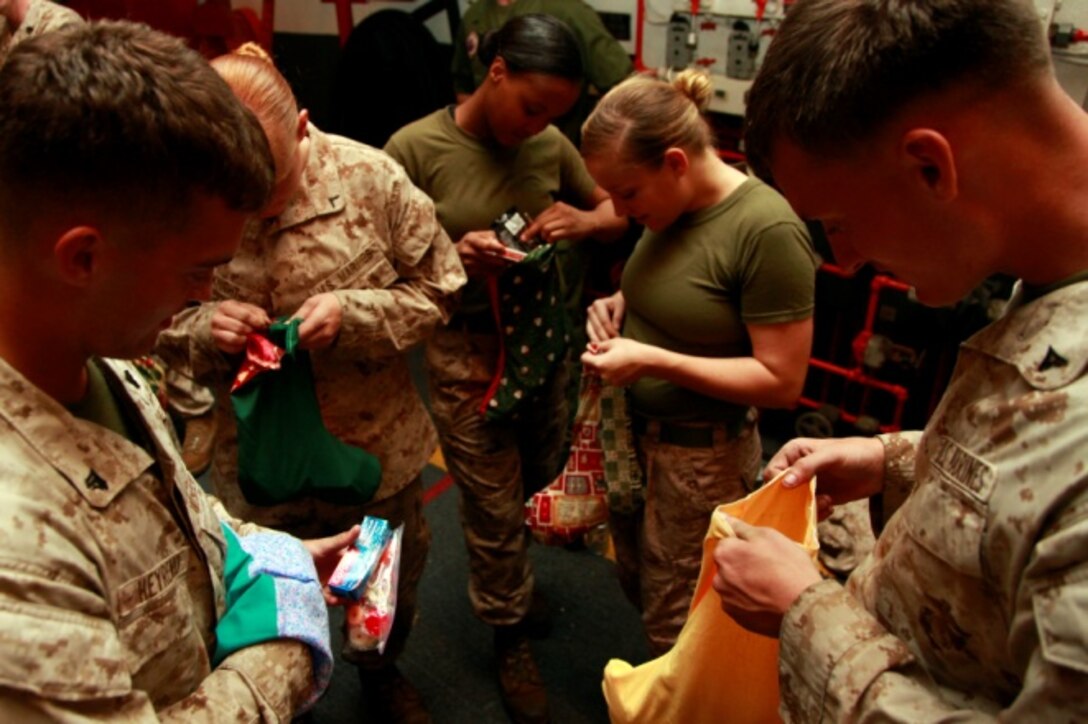 Captain Charles D. Jordan, CH-46E Sea Knight pilot, Marine Medium Helicopter Squadron 364 (Rein.), 15th Marine Expeditionary Unit, passes out stockings donated to the unit for Christmas in the hangar bay of the USS Peleliu, Dec. 14. The gifts were donated to the unit by Operation Santa, a charity group coordinated through the unit’s family readiness officer to provide stockings to deployed servicemembers. The 15th MEU is deployed as part of the Peleliu Amphibious Ready Group as a U.S. Central Command theater reserve force, providing support for maritime security operations and theater security cooperation efforts in the U.S. 5th Fleet area of responsibility. Jordan, 27, is from Nashville, Tenn. 