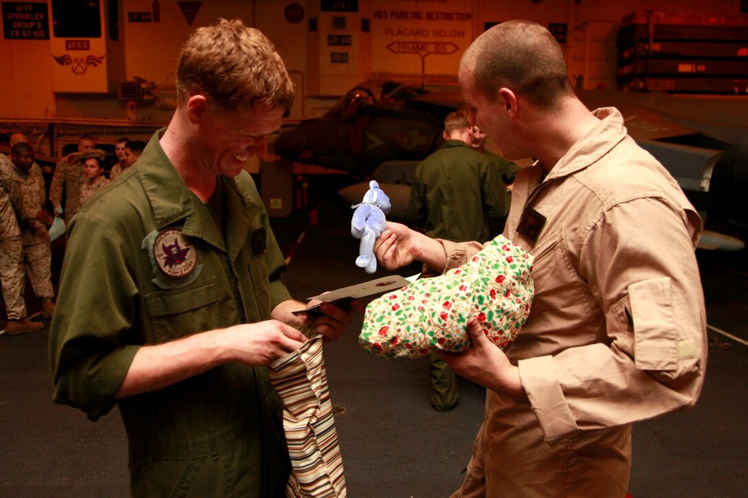 Lance Cpls. Christopher R. Broyles (left) and Wade J. Gieske, both CH-53E Super Stallion crew chiefs with Marine Medium Helicopter Squadron 364 (Rein.), 15th Marine Expeditionary Unit, , look inside the stockings they received for Christmas in the hangar bay of the USS Peleliu, Dec. 14. The gifts were donated to the unit by Operation Santa, a charity group coordinated through the unit’s family readiness officer to provide stockings to deployed servicemembers. The 15th MEU is deployed as part of the Peleliu Amphibious Ready Group as a U.S. Central Command theater reserve force, providing support for maritime security operations and theater security cooperation efforts in the U.S. 5th Fleet area of responsibility. Broyles, 22, is from Scappoose, Ore., and Gieske, 21, is from Hart, Mich. 