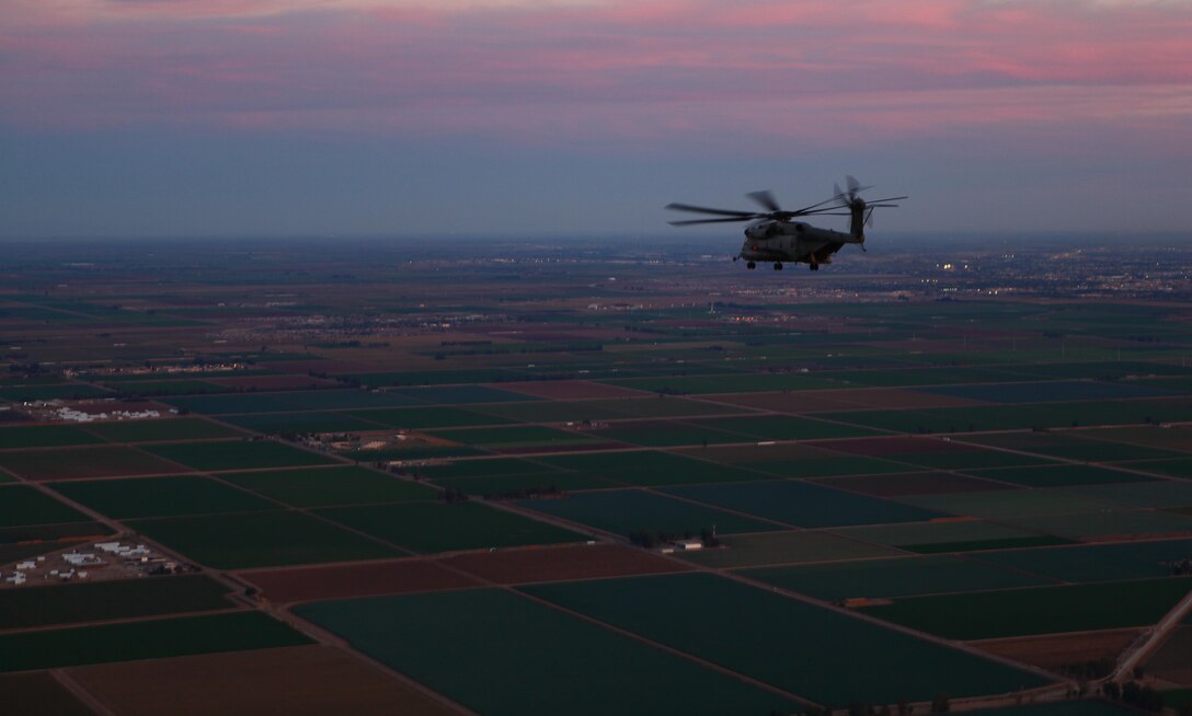 A CH-53E Super Stallion flies over properties outside of El Centro, Calif., on the way to a weapons training range Dec. 20. Once authorized to begin firing, pilots and crew members will work together while firing their weapon systems at targets on the ground to train for combat situations where firing at the enemy is used to suppress fire for troop transport missions.