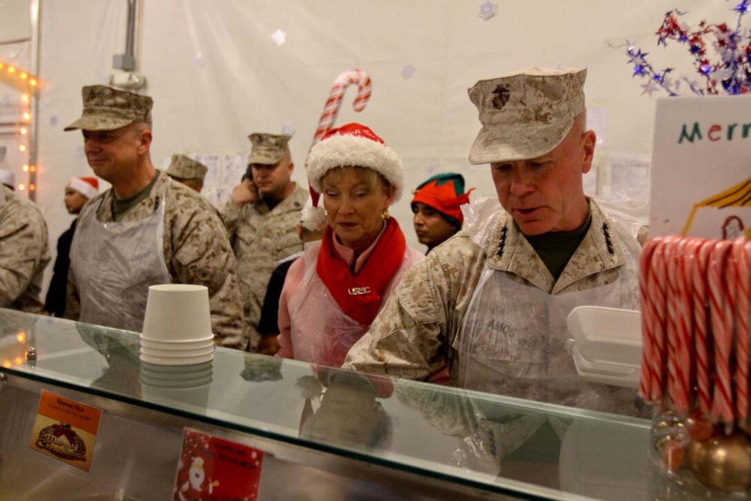 General James F. Amos, right, commandant of the Marine Corps, with his wife Bonnie and Gen. John R. Allen, left, commanding general, International Security Assistance Force, serve food to servicemembers aboard Camp Leatherneck, Afghanistan, Dec. 25, 2012. The leaders visited several different bases in the area, talking to deployed servicemembers who are away from their families this holiday season.