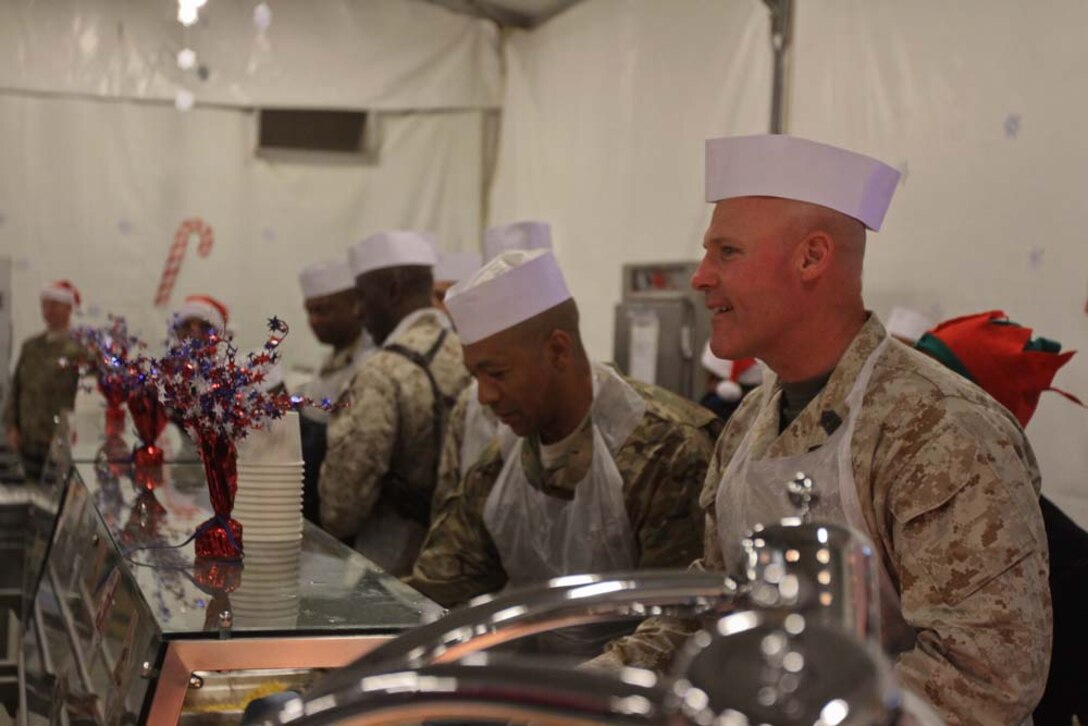 Sergeant Maj. of the Marine Corps Micheal P. Barrett, right, serves Christmas dinner to servicemembers aboard Camp Leatherneck, Afghanistan, Dec. 25, 2012. Sergeant Maj. Barrett traveled throughout Helmand province, speaking to servicemembers who are deployed during the holiday season.