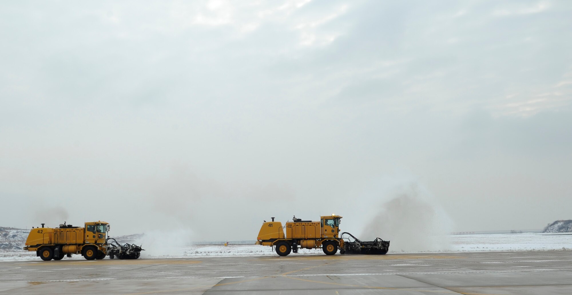 Airmen from the 8th Civil Engineer Squadron continue the snow removal process, Dec. 28, 2012, at Kunsan Air Base, Republic of Korea. The lengthy process requires them to coordinate with many units, including airfield management and barrier maintenance, to get the flightline ready for use. (U.S. Air Force photo by Senior Airman Brigitte N. Brantley/Released)