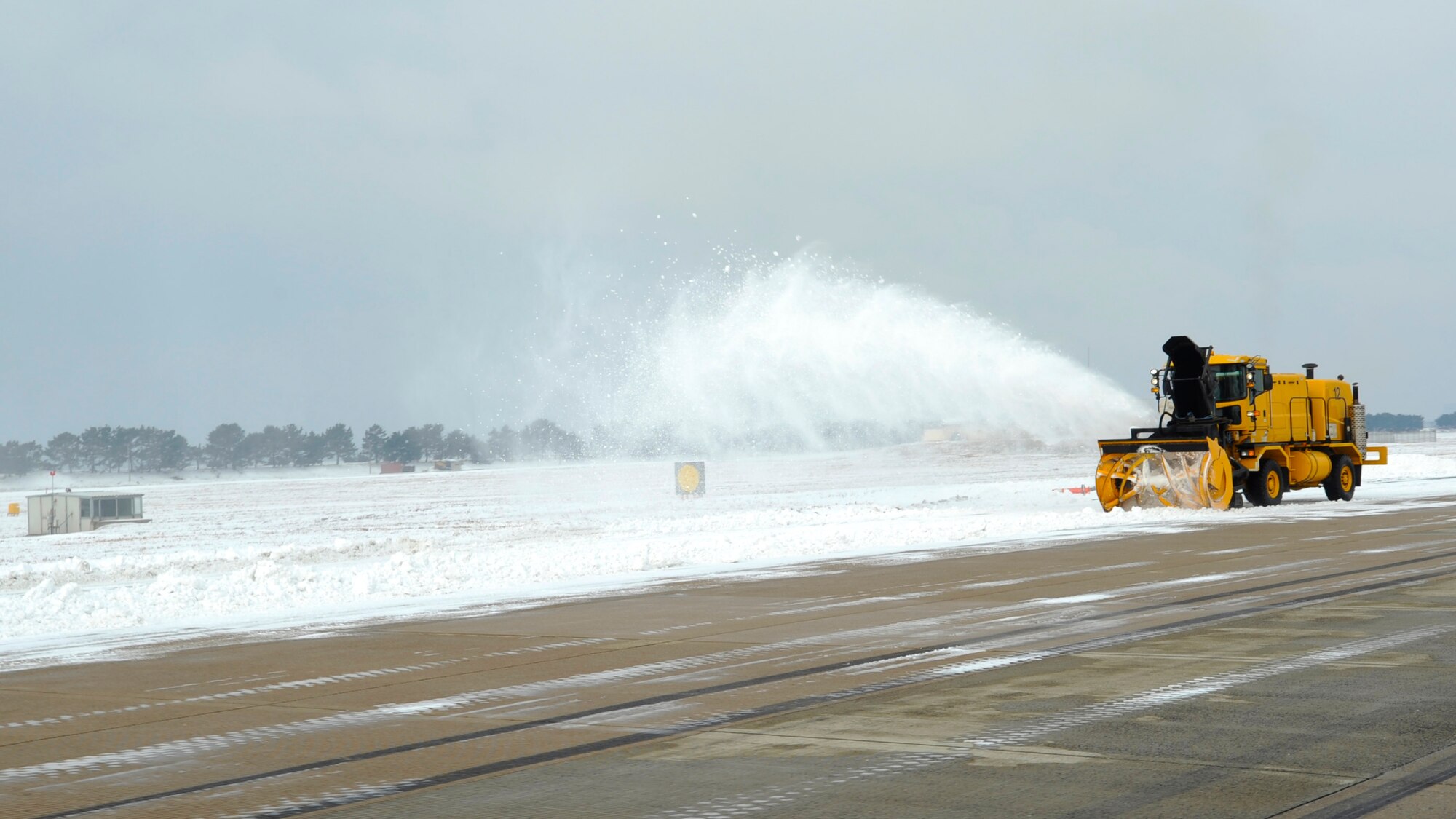 Staff Sgt. Sheldon Mellott, 8th Civil Engineer Squadron, uses a snow blower to clear the flightline for F-16 Fighting Falcons to take off, Dec. 28, 2012, at Kunsan Air Base, Republic of Korea. The pavement must meet certain safety and readiness requirements before the aircraft are allowed to taxi or take off. (U.S. Air Force photo by Senior Airman Brigitte N. Brantley/Released)