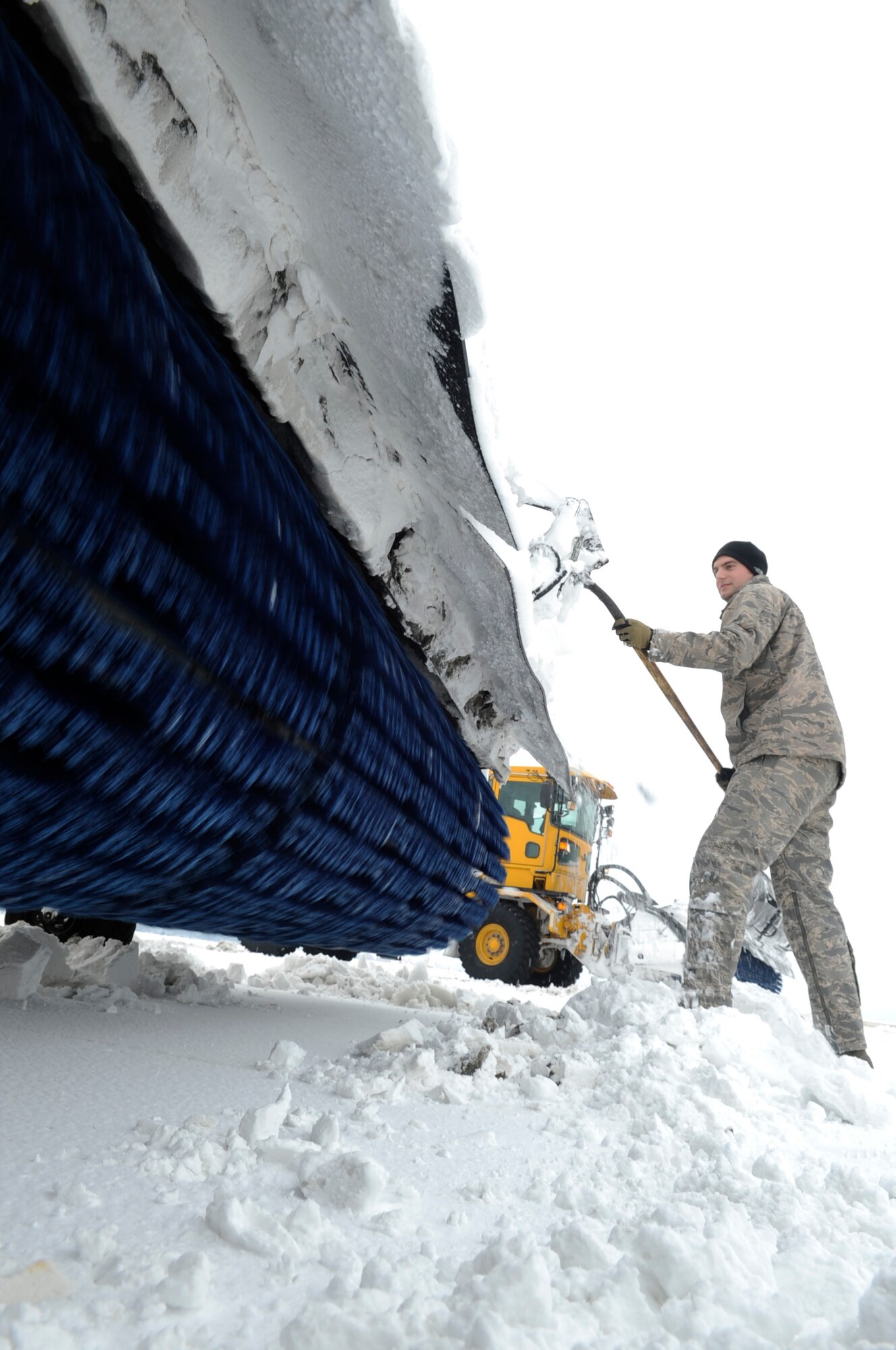 Senior Airman Jacob Baker, 8th Civil Engineer Squadron, removes built-up ice from his sweeper before continuing snow removal on the flightline Dec. 28, 2012, at Kunsan Air Base, Republic of Korea. Many CE shops have been working 12-hour shifts since the base’s first snowfall to make sure the mission doesn’t stop. (U.S. Air Force photo by Senior Airman Brigitte N. Brantley/Released)