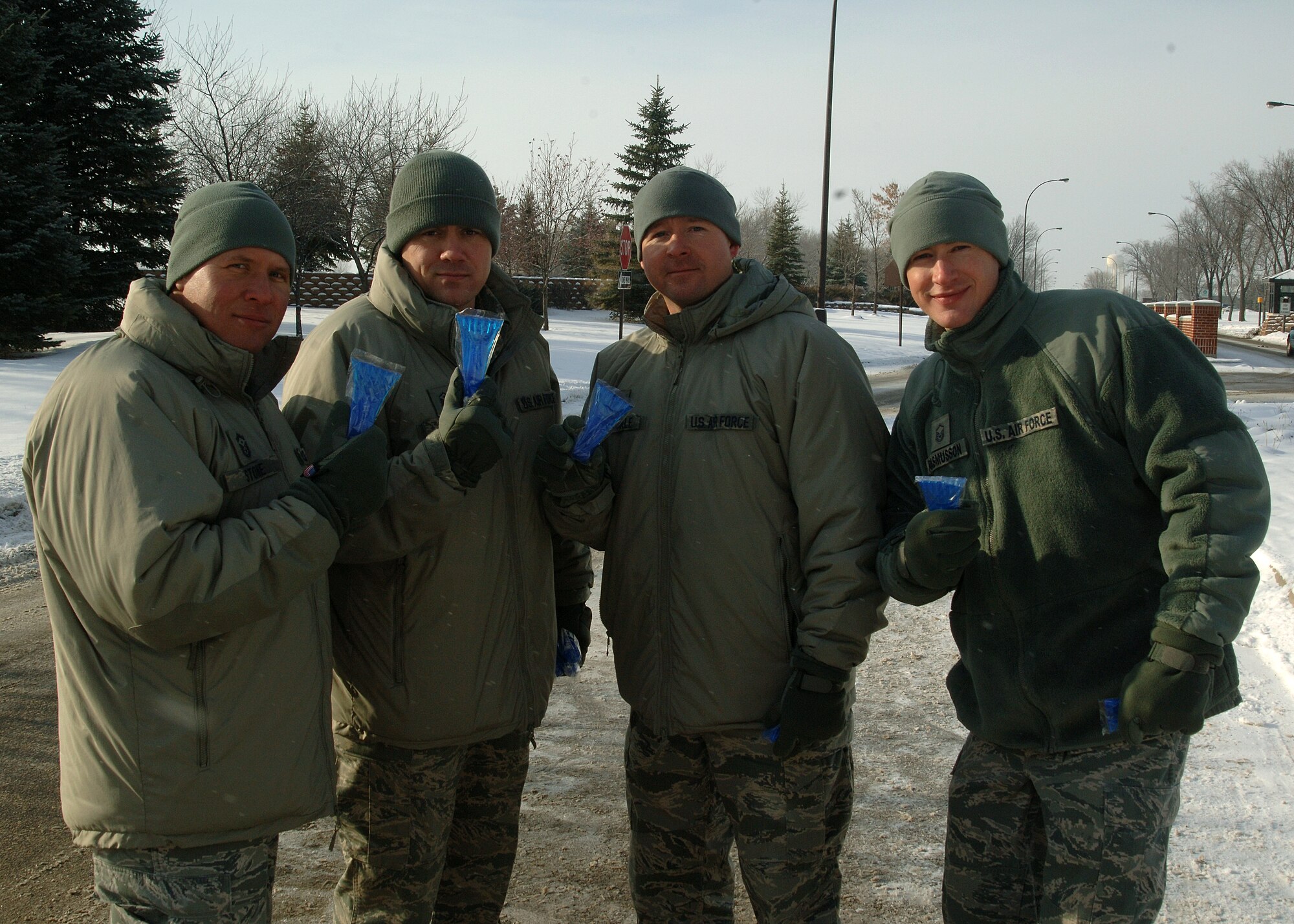 First sergeants from the 319th Air Base Wing hold up Airmen Against Drunk Driving imprinted vehicle ice-scrappers Dec. 28, 2012, on Grand Forks Air Force Base, N.D. AADD raised money throughout 2012 by conducting various fundraisers which helped pay for ice-scrapers given out that day. (U.S. Air Force photo/Airman 1st Class Zachiah Roberson)