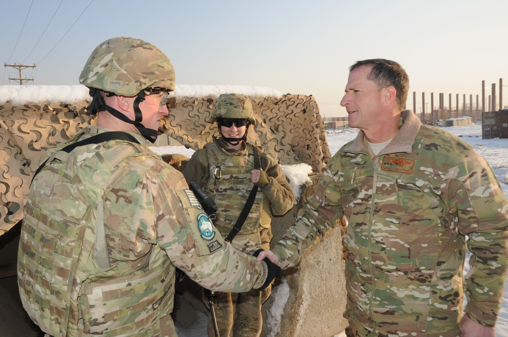 BAGRAM AIRFIELD, Afghanistan - Lt. Gen. David Goldfein, U.S. Air Forces Central Command commander, greets Staff Sgt. Joseph Stang (left) and Senior Airman Sheila Smith, 455th Expeditionary Maintenance Squadron crash recovery technicians, during a readiness exercise here, Dec. 31, 2012. The exercise tested the ability of maintenance Airmen to integrate with security forces in order to protect vital assets during a potential ground attack. (U.S. Air Force photo/Staff Sgt. David Dobrydney)
