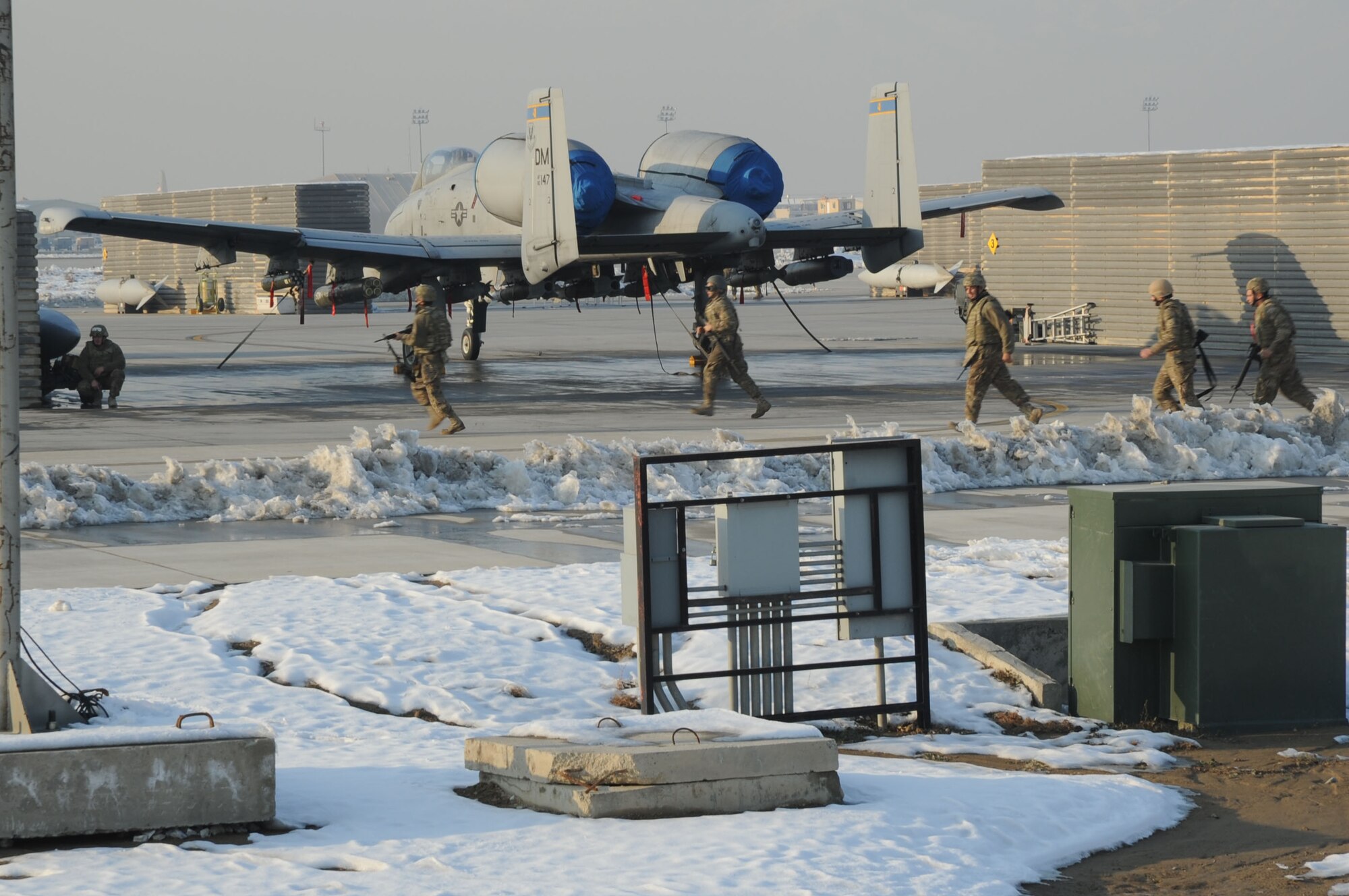 BAGRAM AIRFIELD, Afghanistan - Airmen run to their defensive positions during an exercise on the flightline here, Dec. 31, 2012. The exercise was to practice the integration of maintenance Airmen with security forces in order to protect vital assets during a potential ground attack. (U.S. Air Force photo/Staff Sgt. David Dobrydney)