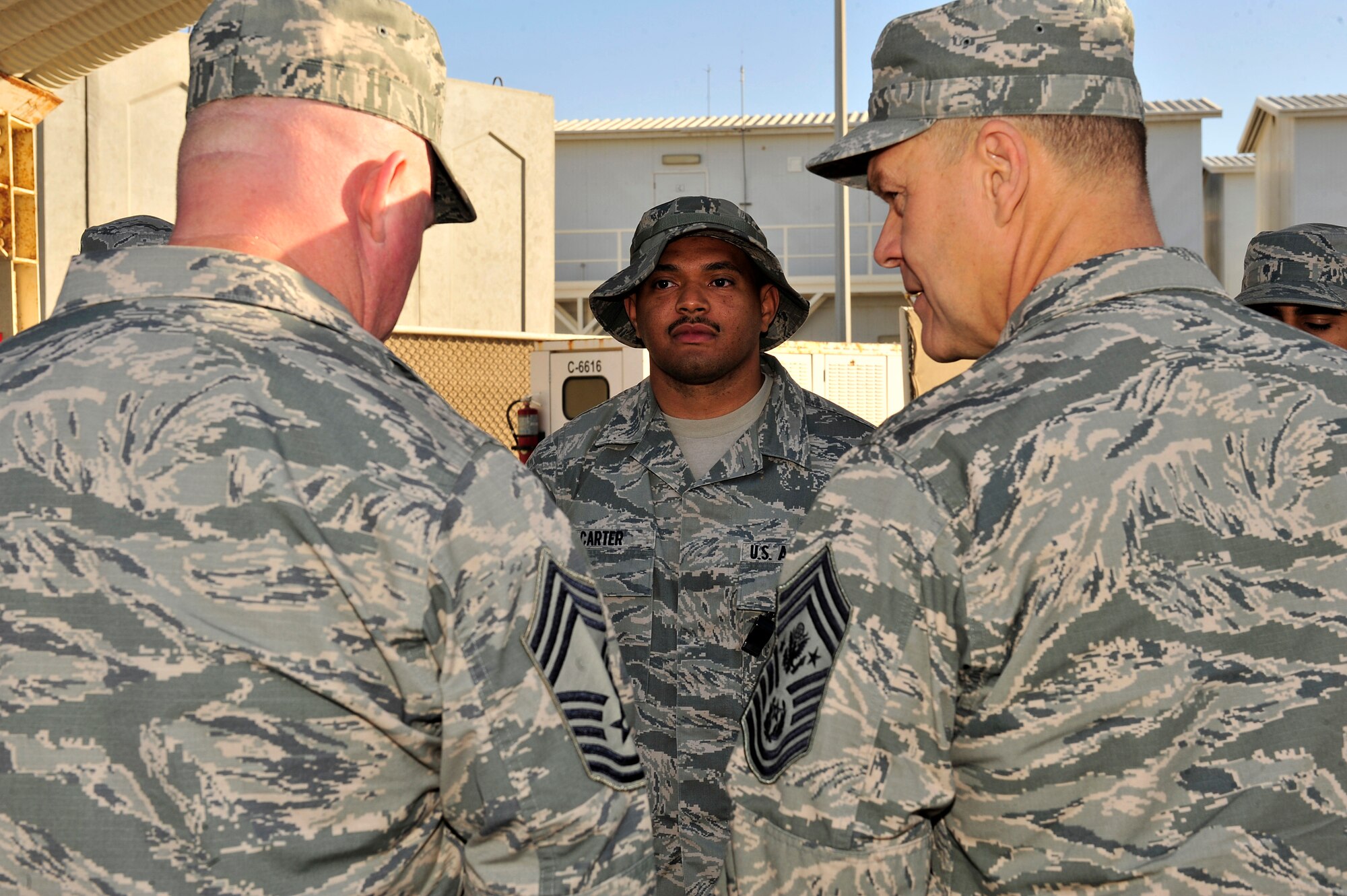 SOUTHWEST ASIA -- Chief Master Sgt. of the Air Force James Roy and Chief Master Sgt. Derick Stepp, 380th Expeditionary Security Forces Squadron, speak to Senior Airman Justin Carter, 380th ESFS force protection, about his favorite football team Dec. 30, 2012. Roy accompanied Secretary of the Air Force Michael Donley on a visit to the 380th Air Expeditionary Wing as part of a multi-base tour to meet with Airmen and deployed service members within the European and Central Command areas of responsibility. (U.S. Air Force photo/Tech. Sgt. Christina M. Styer)
