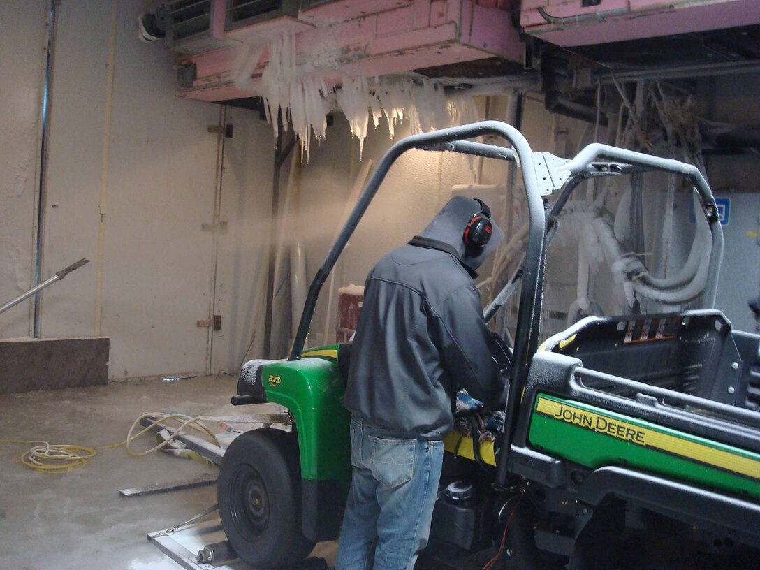 John Deere Designer II Scott Macco checks a test vehicle recently while conducting icing tests at ERDC-CRREL. During this phase of the testing, the room was at minus 15 degrees Fahrenheit. To the left in the photograph, a snow gun blows snow at the vehicle and as the room warms, ice will form.