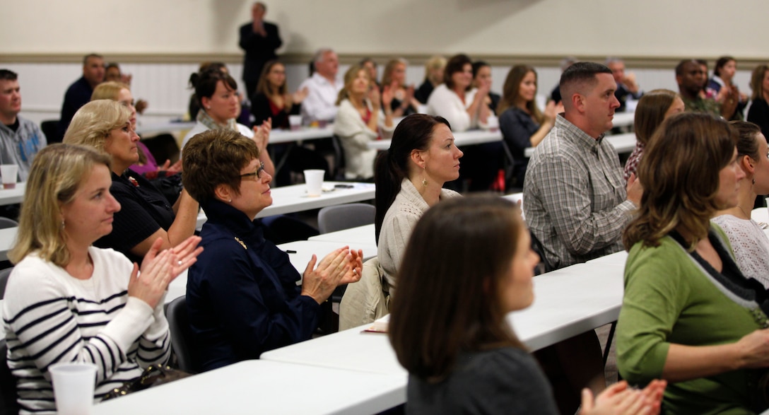 Patrons in attendance to hear retired Medal of Honor recipients Maj. Gen. James Livingston and Army Maj. Drew Dix applaud the two retirees after they spoke on the importance of the role of a military spouse. Attendees were able to ask a barrage of questions about military households, and the speakers provided valuable, first-hand answers about spousal support and strengthening relationships. 