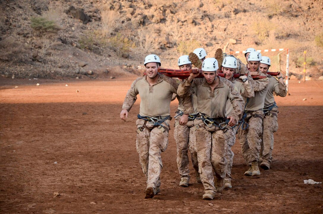 Marines assigned to the 15th Marine Expeditionary Unit (MEU) carry a metal stretcher while performing a team-building obstacle course at Arta Beach, Djibouti, Dec. 11. 15th MEU is deployed as part of the Peleliu Amphibious Ready Group as a U.S. Central Command theater reserve force, providing support for maritime security operations and theater security cooperation efforts in the U.S. 5th Fleet area of responsibility. (U.S. Marine Corps photo by Cpl. Richard Sanglap-Heramis/Released)